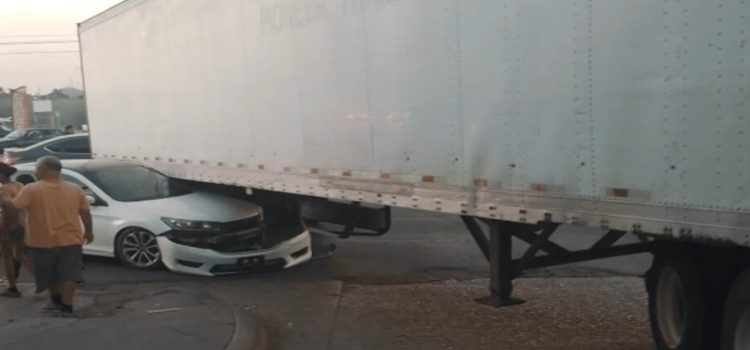 Sedán termina debajo de un tráiler Freighliner